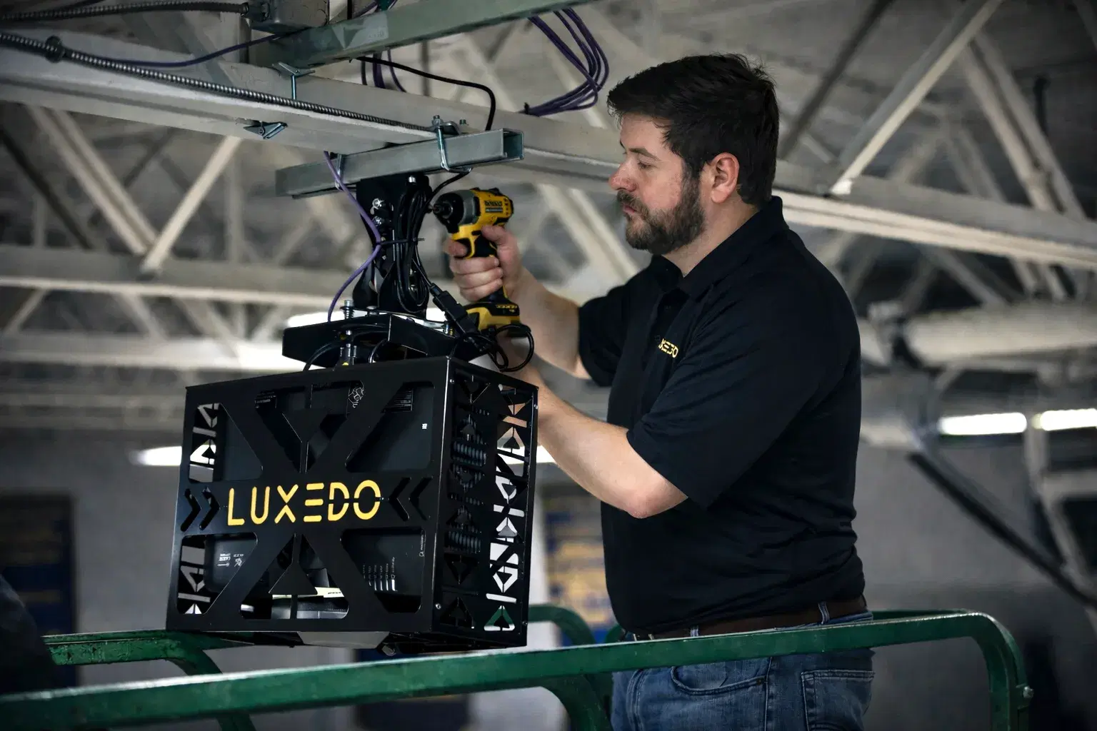 Luxedo technician mounting a projector for a basketball court projection mapping system installation